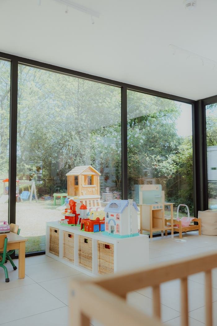 Lichte speelruimte met houten speelhuisje en zicht op de tuin